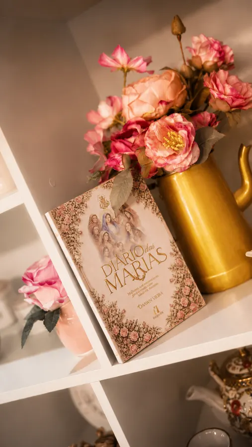 Livro Diário das Marias na estante com flores